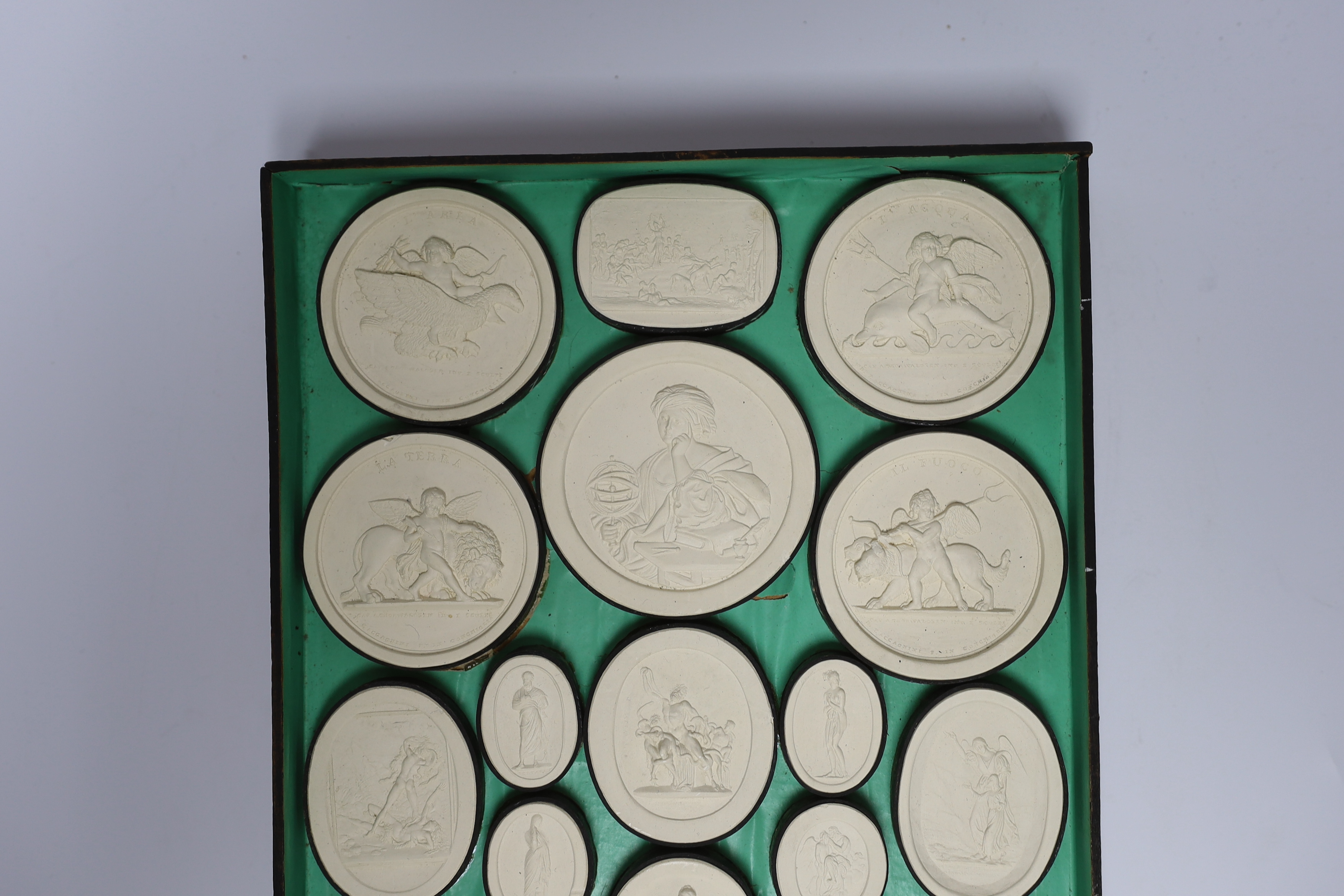 A cased set of thirty two Italian Grand Tour plaster roundels after intaglios of various subjects